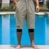 Sarouel de bain Haytam gris kaki porté au bord d'une piscine - vue de face