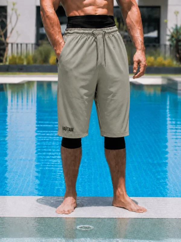 Sarouel de bain Haytam gris kaki porté au bord d'une piscine - vue de face