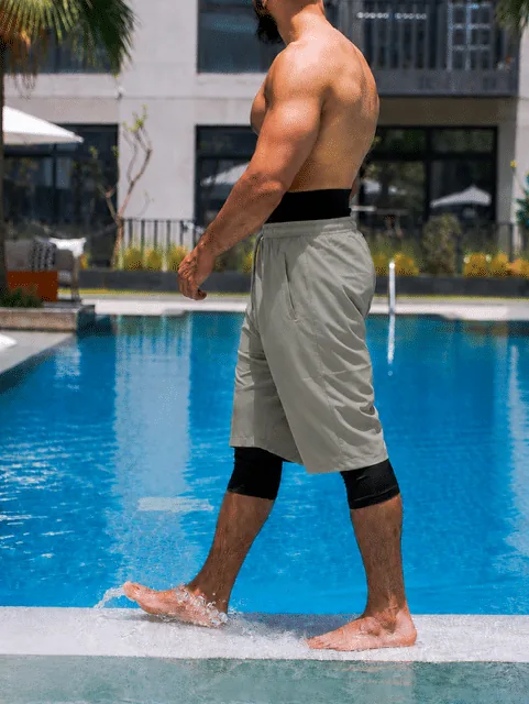 Sarouel de bain Haytam gris kaki porté en mouvement au bord d'une piscine - vue de profil