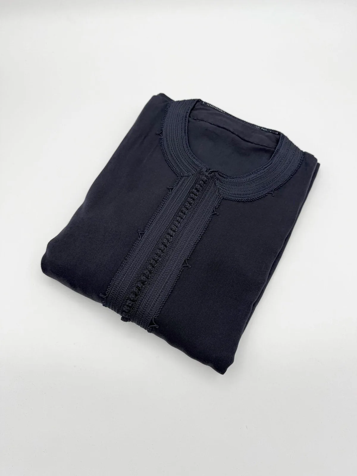 Caftan homme peau de pêche bleu marine, col rond à passementerie, plié